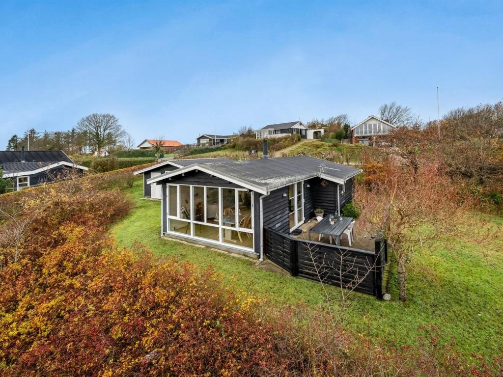 uma pequena casa no topo de uma colina relvada em Holiday Home Dimo - 300m to the inlet in The Liim Fiord by Interhome em Struer