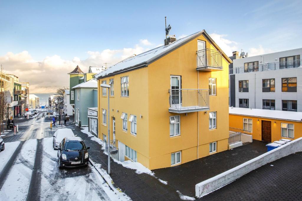 un edificio amarillo al lado de una calle en Alfred's Apartments, en Reikiavik