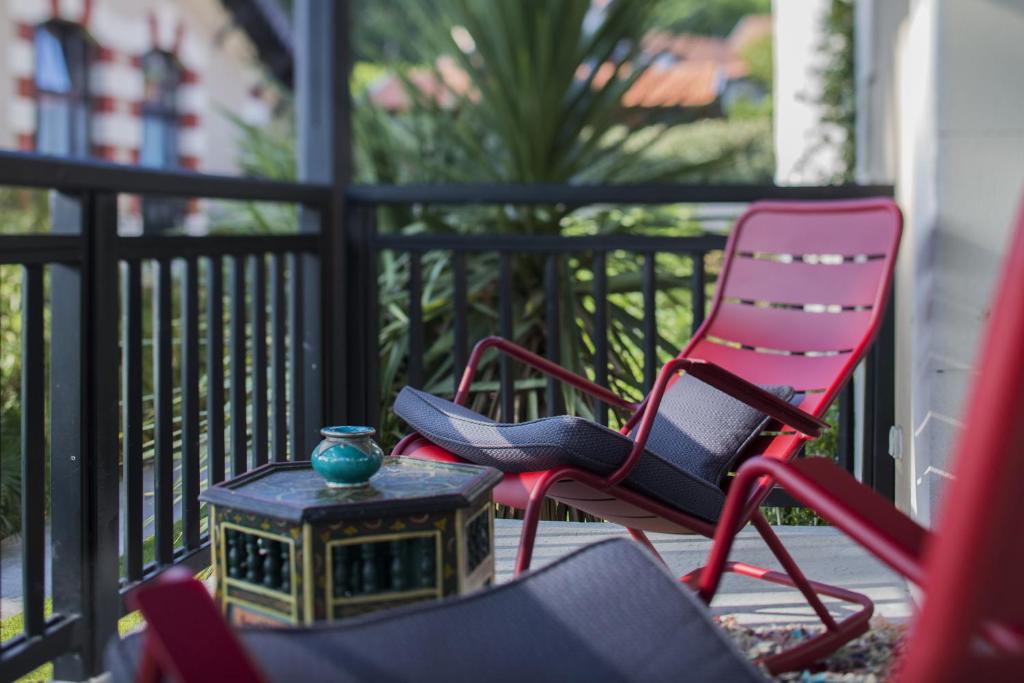 - un groupe de chaises et une table sur une terrasse couverte dans l'établissement Hôtel Ville d'Hiver, à Arcachon