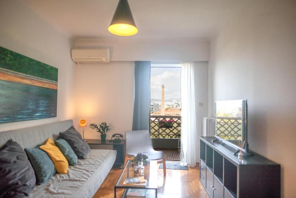 a living room with a couch and a window at Urban Apartment in the Heart of Athens in Athens