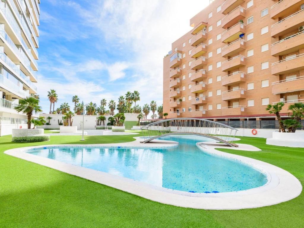uma piscina no meio de um relvado com edifícios em Apartment Miramar by Interhome em Oropesa del Mar