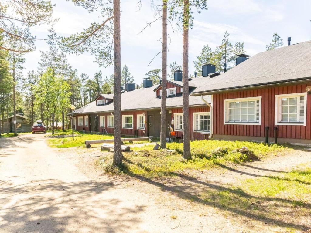 une maison rouge avec des arbres devant elle dans l'établissement Holiday Home Soidinaukia a 3 by Interhome, à Saariselka