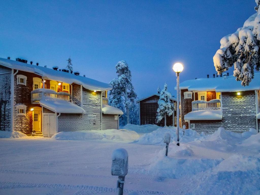 a house covered in snow with a street light at Holiday Home Rautulampi h 23 by Interhome in Saariselka