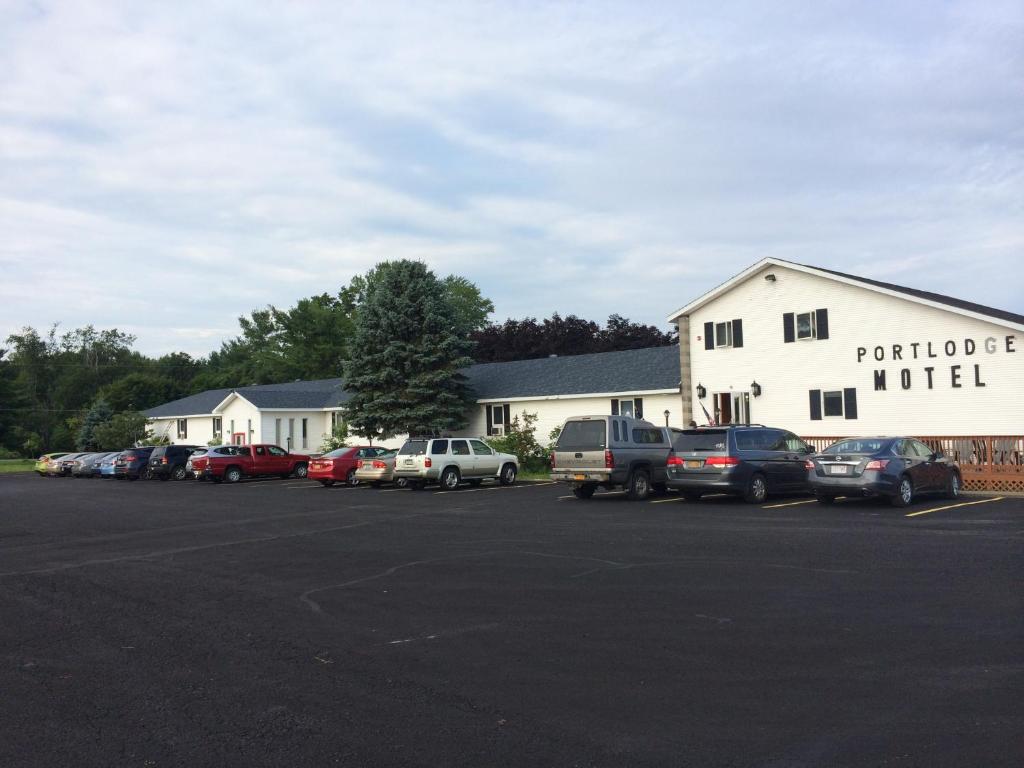 un estacionamiento con autos estacionados frente a un edificio en Port Lodge Motel en Pulaski