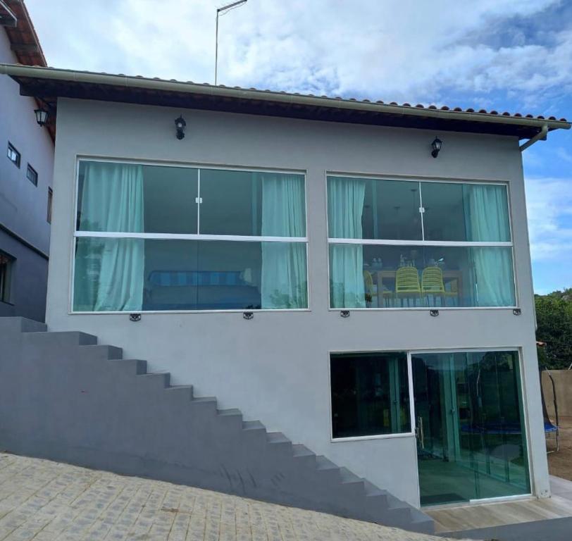 een huis met grote ramen en een trap bij Aconchego da serra in Bezerros