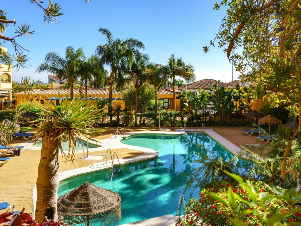 uma piscina num resort com uma palmeira em Apartment Los Almendros I by Interhome em Marbella