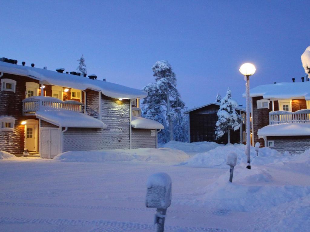 a house covered in snow with a parking meter at Holiday Home Rautulampi g 20 by Interhome in Saariselka