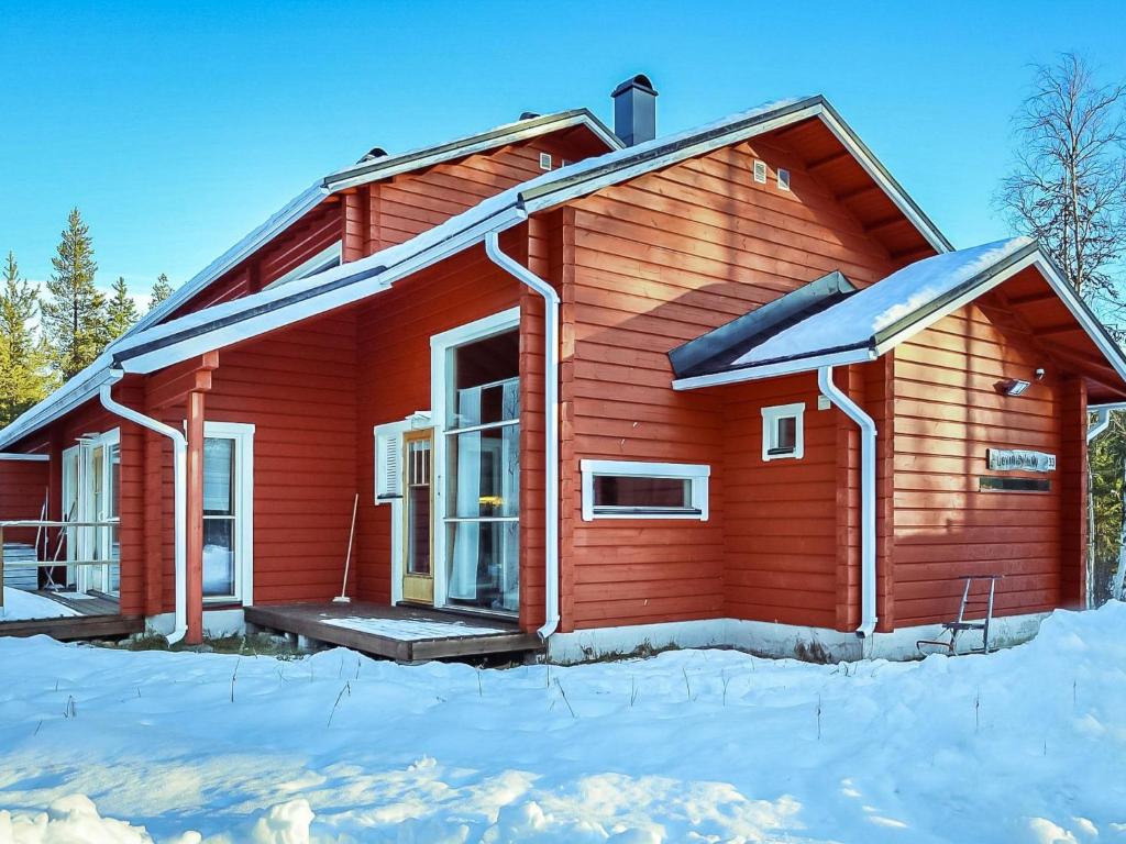 uma casa vermelha com neve no chão em Holiday Home Joutsenlaulu by Interhome em Sirkka