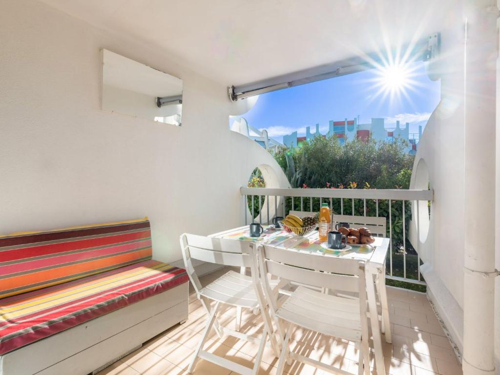 un balcon avec une table, des chaises et une fenêtre dans l'établissement Apartment Ipanema by Interhome, à La Grande Motte