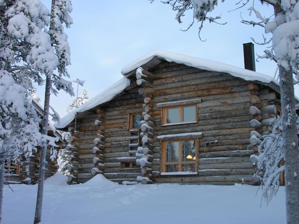 una cabaña de madera en la nieve en Holiday Home Kelowaskooli by Interhome, en Saariselkä