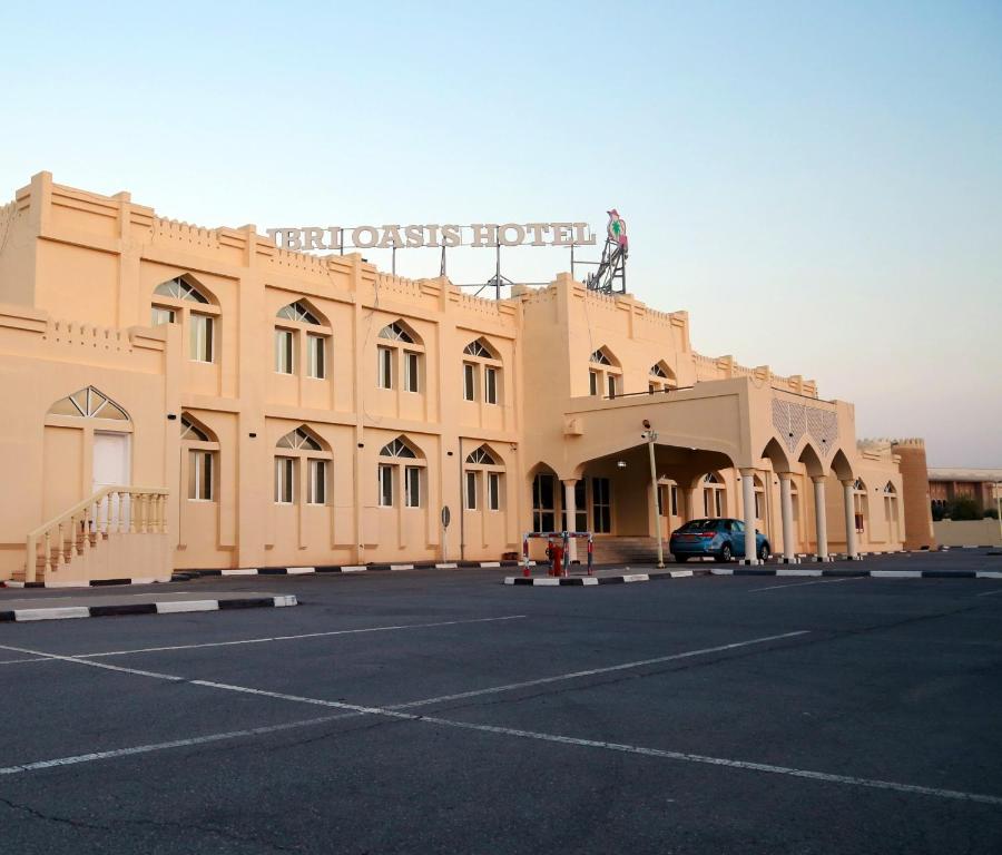 un grand bâtiment avec une statue au-dessus dans l'établissement Ibri Oasis Hotel, à Ibri