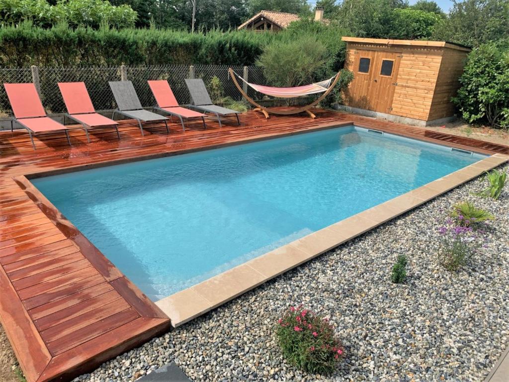 einen Pool mit Stühlen und einer Hängematte im Hinterhof in der Unterkunft Villa Le Faré by Interhome in Azur