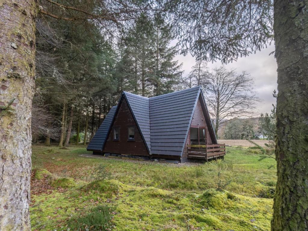 a small cabin in a field with trees at Chalet Lodge 26 by Interhome in Spean Bridge