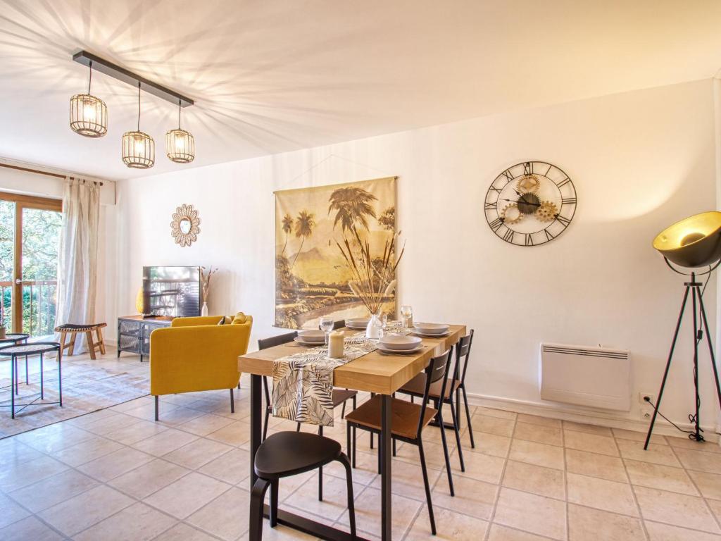 une salle à manger avec une table, des chaises et une horloge dans l'établissement Apartment Le Capricorne by Interhome, à Saint-Raphaël