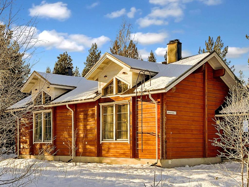 a wooden house with snow on the ground at Holiday Home Jytilevi a by Interhome in Sirkka