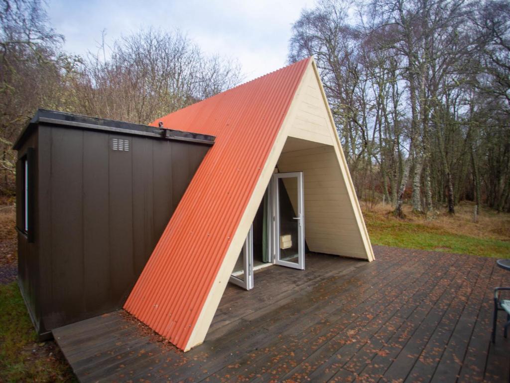 um barracão com telhado laranja e uma porta aberta em Chalet Nessie 1 by Interhome em Drumnadrochit