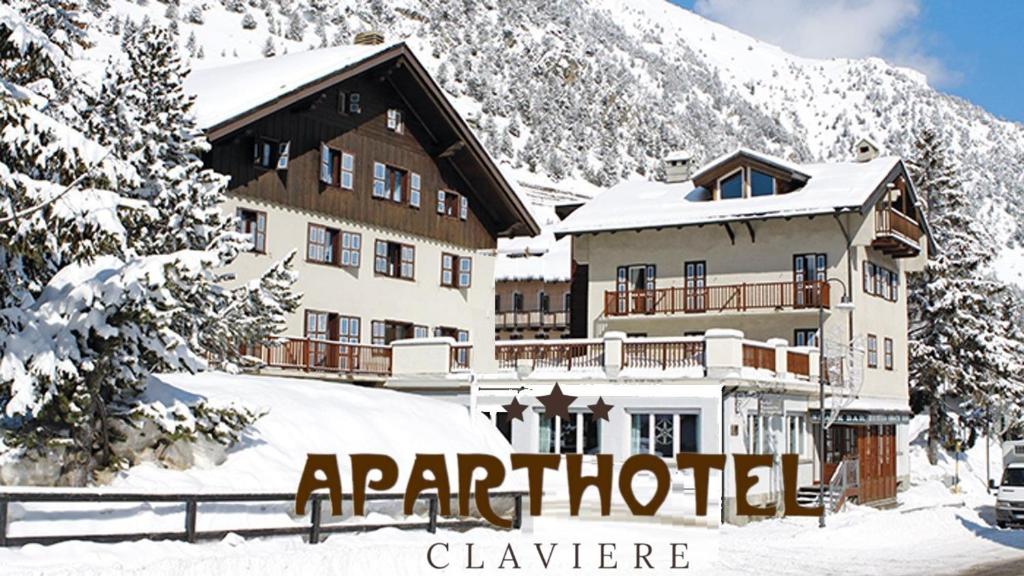 a building in the snow in front of a mountain at Aparthotel Claviere in Claviere