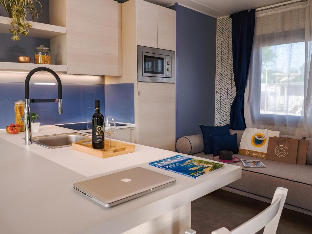 a kitchen with a table with a laptop on it at Pineta Beach Village in Milano Marittima
