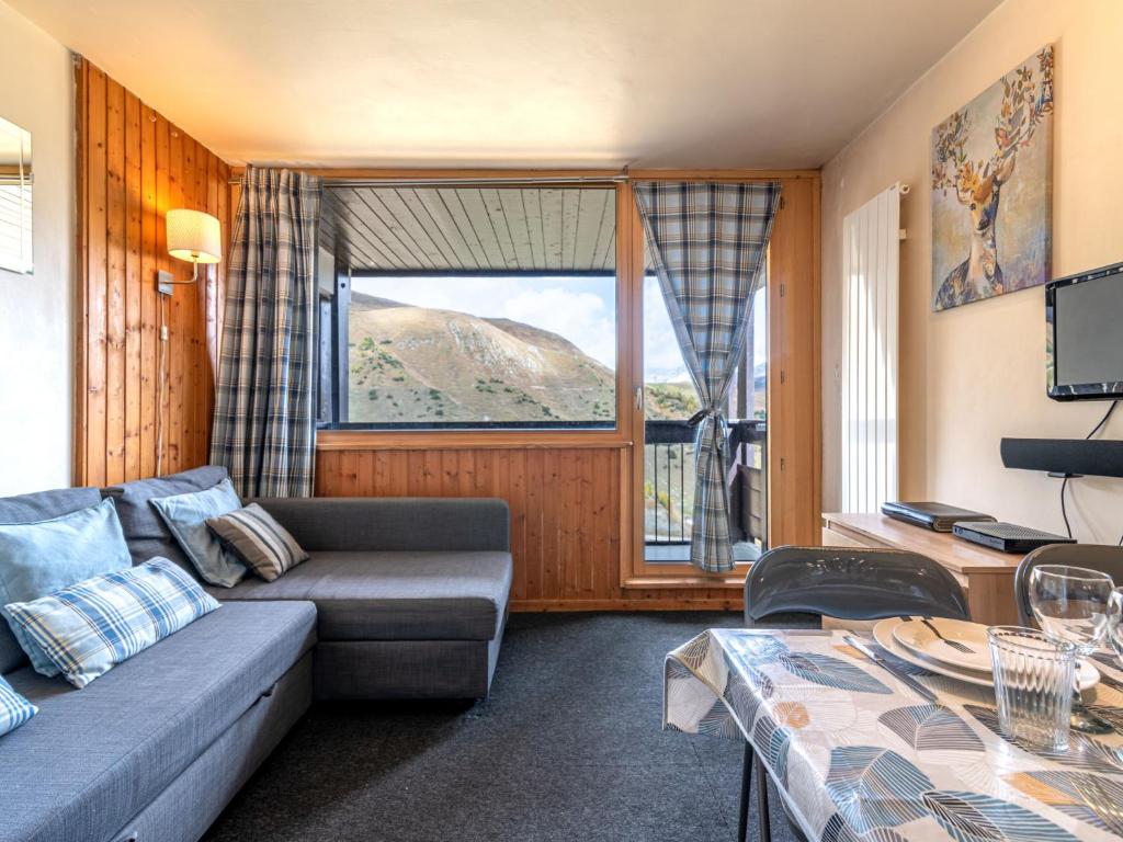 - un salon avec un canapé et une grande fenêtre dans l'établissement Studio Home Club - Lavachet-12 by Interhome, à Tignes