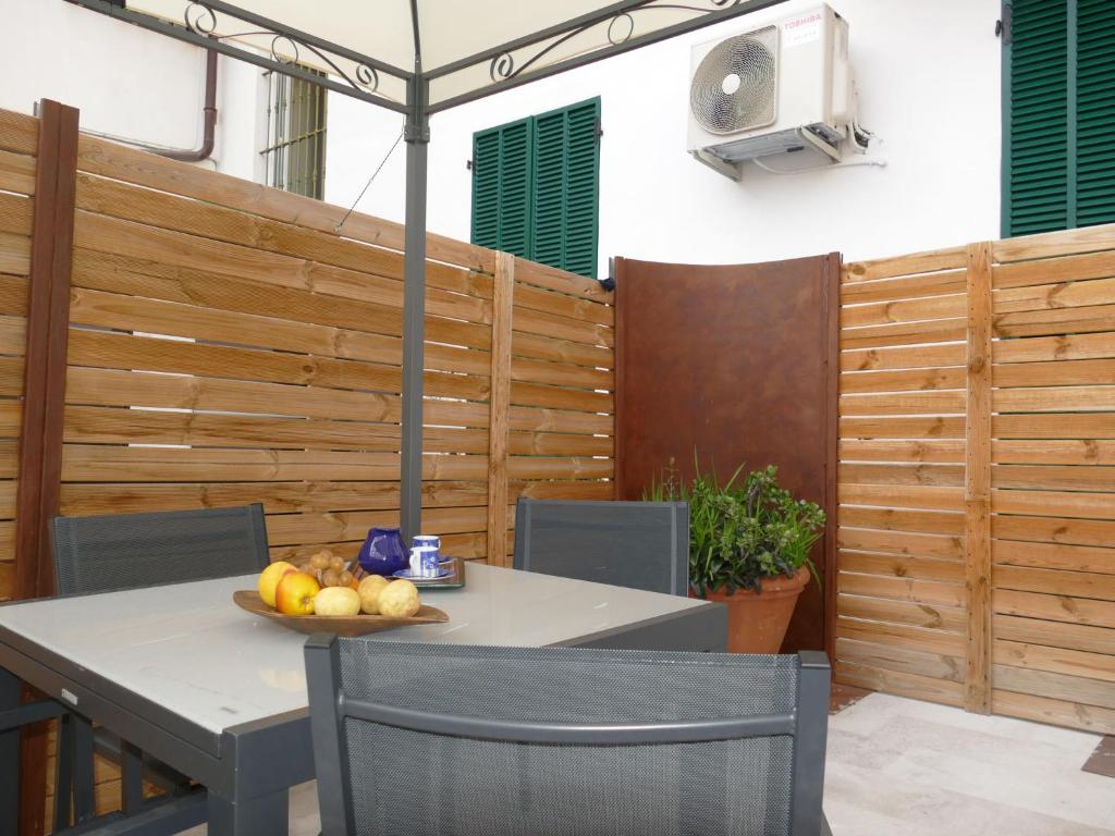 a table and chairs with a bowl of fruit on it at Apartment Fiori e Canzoni by Interhome in Sanremo