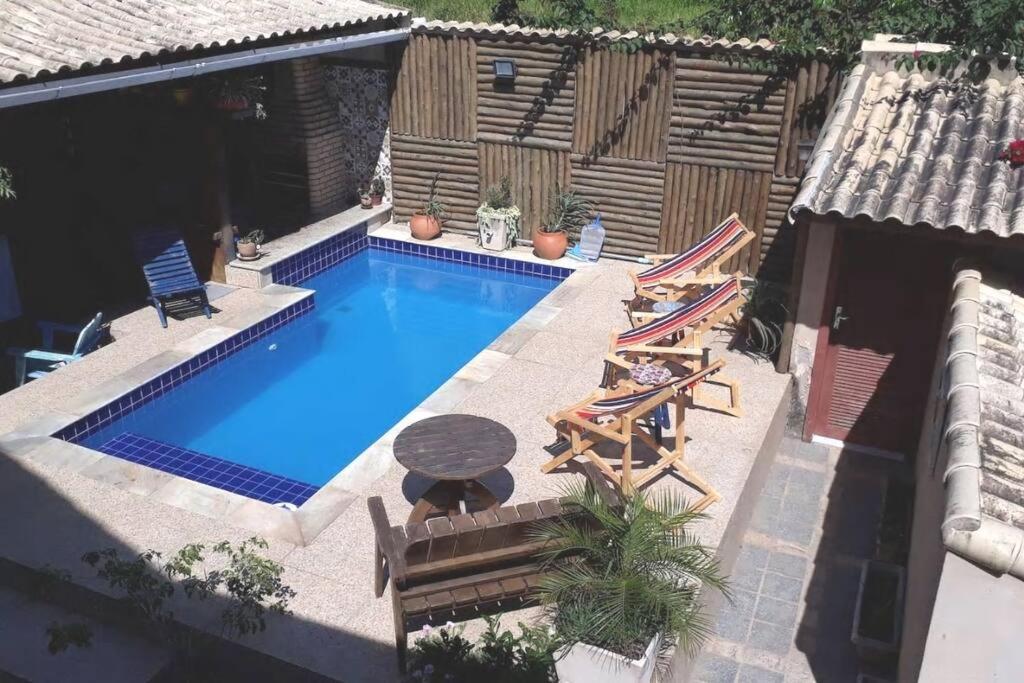 an overhead view of a swimming pool with chairs and a table at Casa completa + área gourmet in Búzios