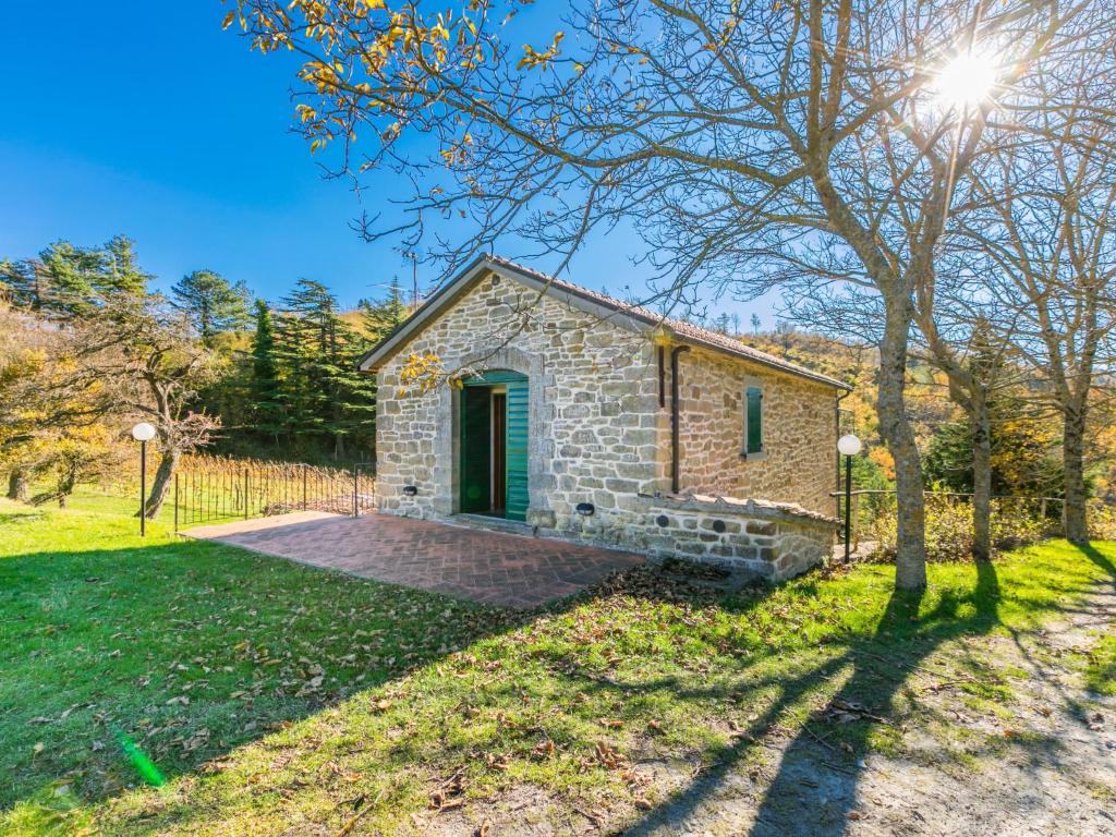 una casa de piedra con una puerta verde en un campo en Holiday Home Al Volo del Nibbio-2 by Interhome, en Marradi