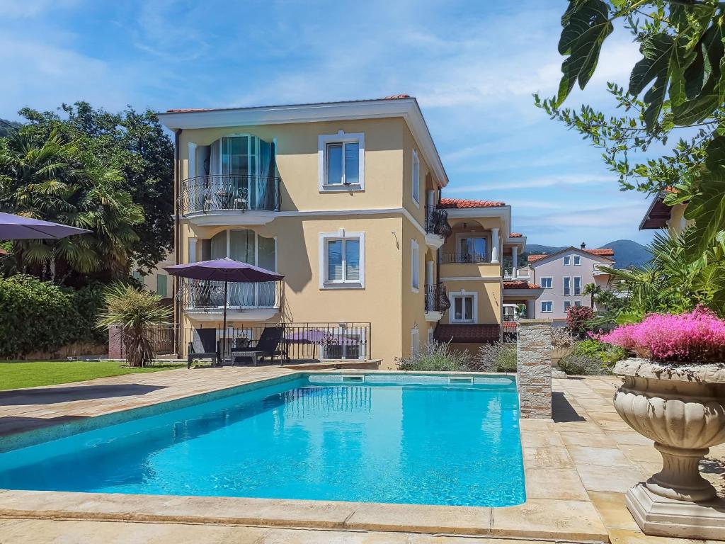 una villa con piscina di fronte a una casa di Holiday Home Villa Palazzo by Interhome a Lovran (Laurana)