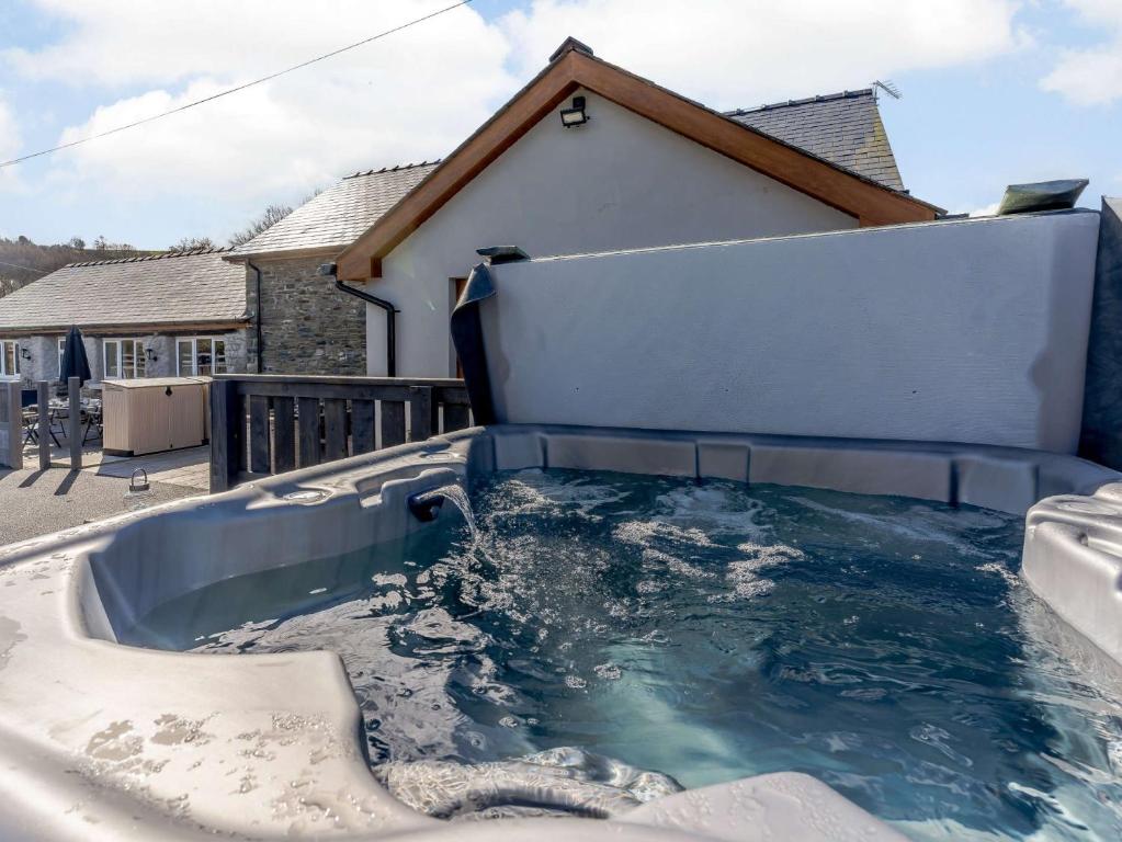 a bathtub filled with water in front of a house at 2 Bed in Lampeter 86507 in Cellan