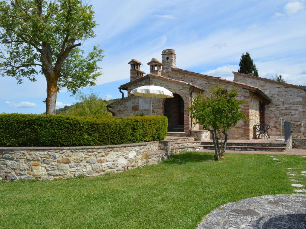 une ancienne maison en pierre avec un mur en pierre et un arbre dans l'établissement Apartment Pontevecchio by Interhome, à Asciano