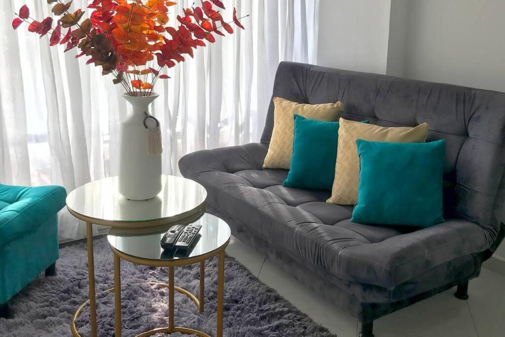 バランカベルメハにあるAcogedor apartamento en Barrancabermejaのリビングルーム(青い枕とグレーのソファ付)