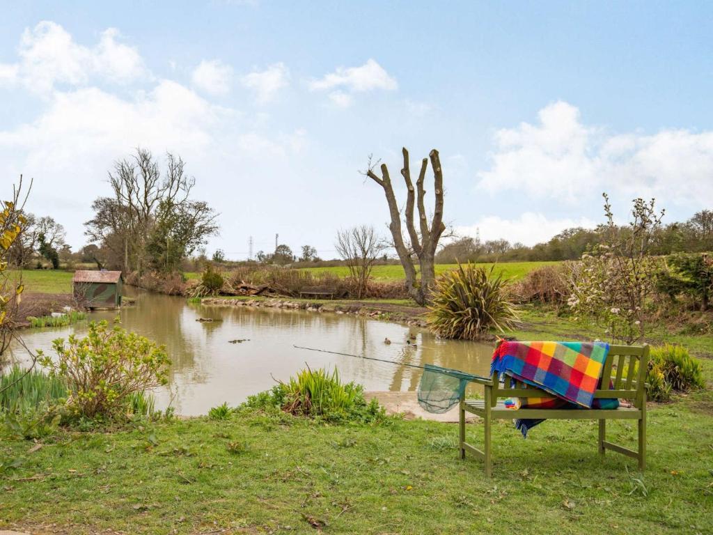 a bench sitting in front of a pond at 1 Bed in Hawarden 86711 in Hawarden