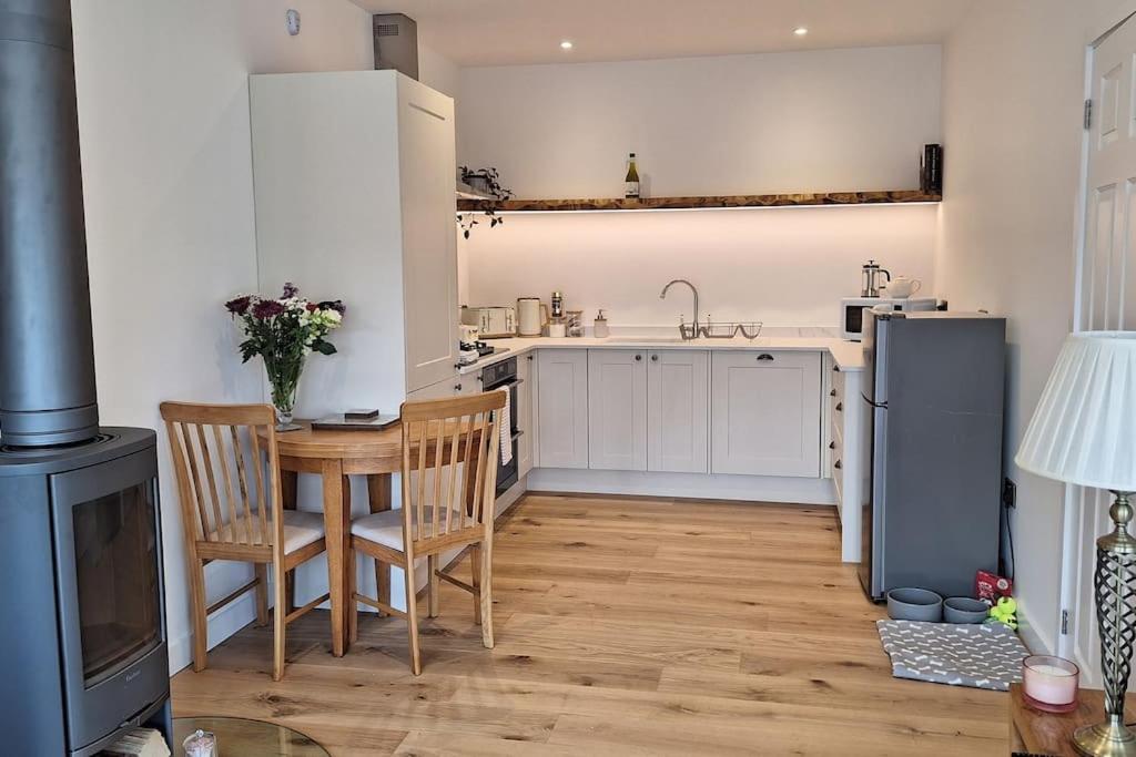 a kitchen with a table and chairs and a refrigerator at Rural Cornish Cottage in Truro