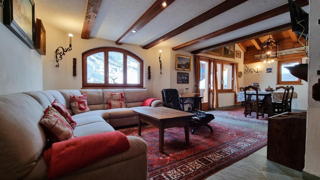 a living room with a couch and a table at Haus Tiefbach - Apartment Cervino in Zermatt