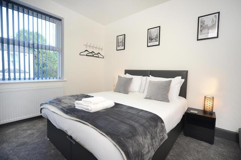 um quarto com uma cama com lençóis brancos e uma janela em Executive 8 Beds 2 Bath Home Contractors Parking em Southampton