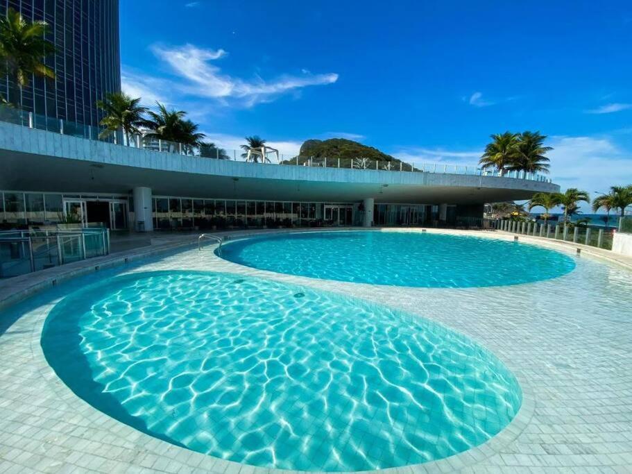 a large swimming pool in front of a building at Quarto no Hotel Nacional com vista mar para a Praia de São Conrado, RJ in Rio de Janeiro