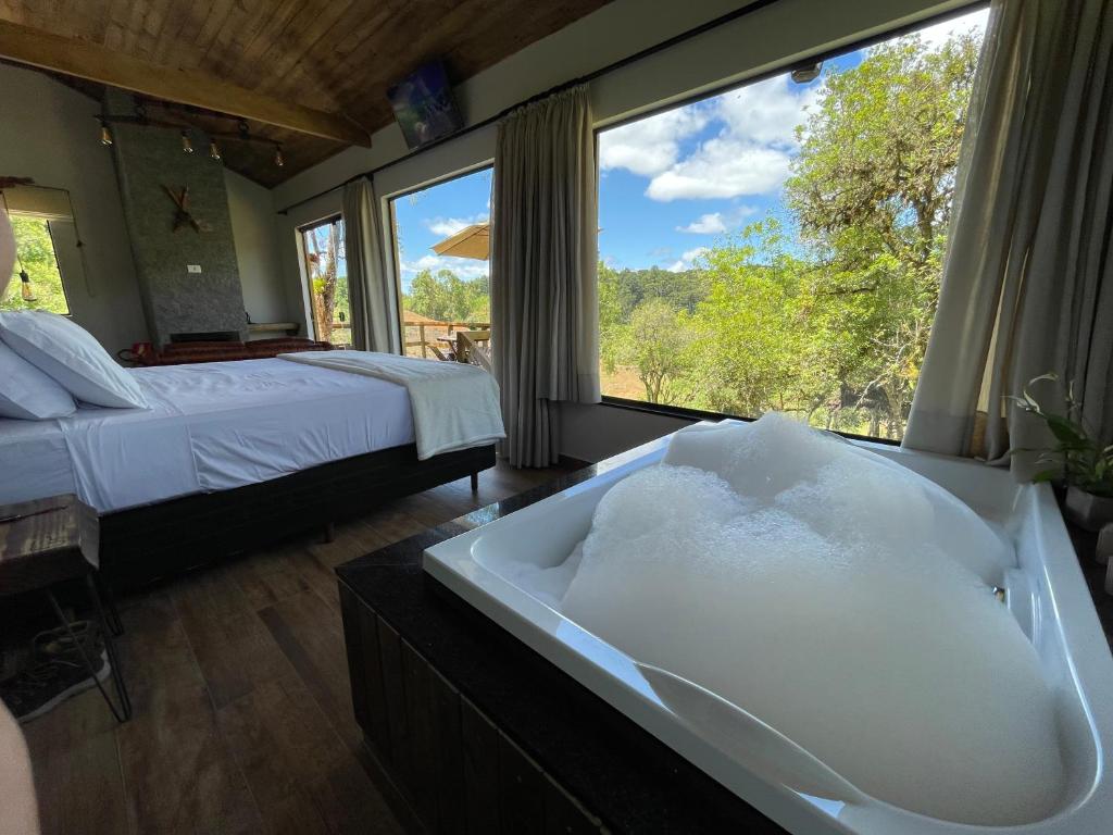 Cabana Rustica في كواترو باراس: غرفة نوم مع حوض مع سرير ونافذة