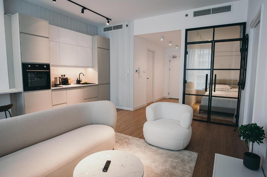 Il comprend un salon avec un canapé et des chaises ainsi qu'une cuisine. dans l'établissement Best Deal!!! Brand New Apartment in Dubai Marina, à Dubaï