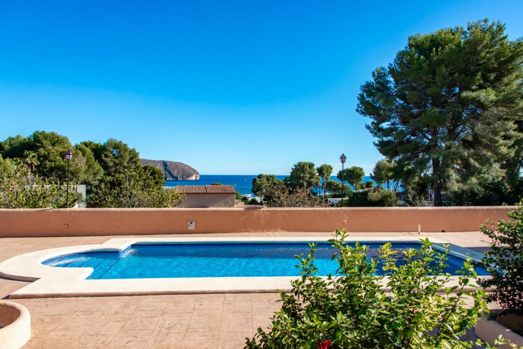 a swimming pool with the ocean in the background at Villas Guzman - Fina in Moraira