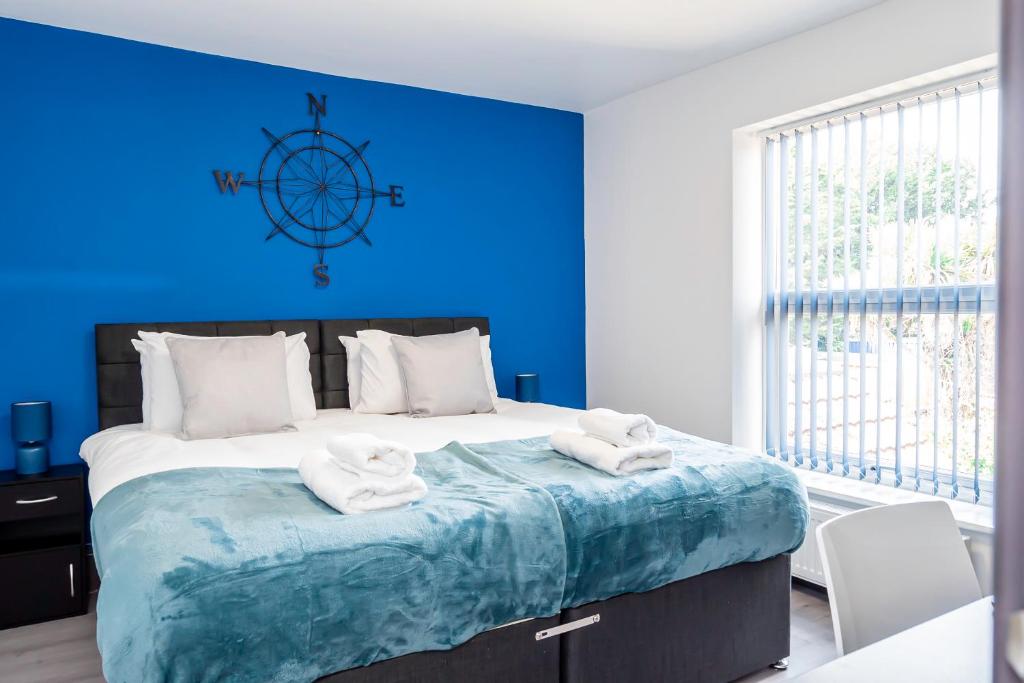 Un dormitorio azul con una cama grande con toallas. en Contractors 8beds Off Road Vanparking 3 Bathrooms, en Southampton