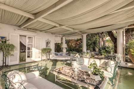 een zwembad met stoelen en een tafel bij GOCCE VILLAS - Green Coral Villa di lusso 1950 in Capri