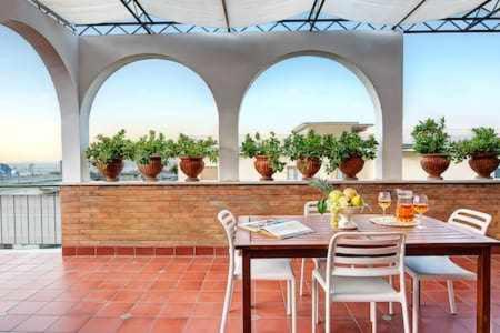 una sala da pranzo con tavolo e sedie di Skyline Sorrento Views in the heart of Sorrento a Sorrento