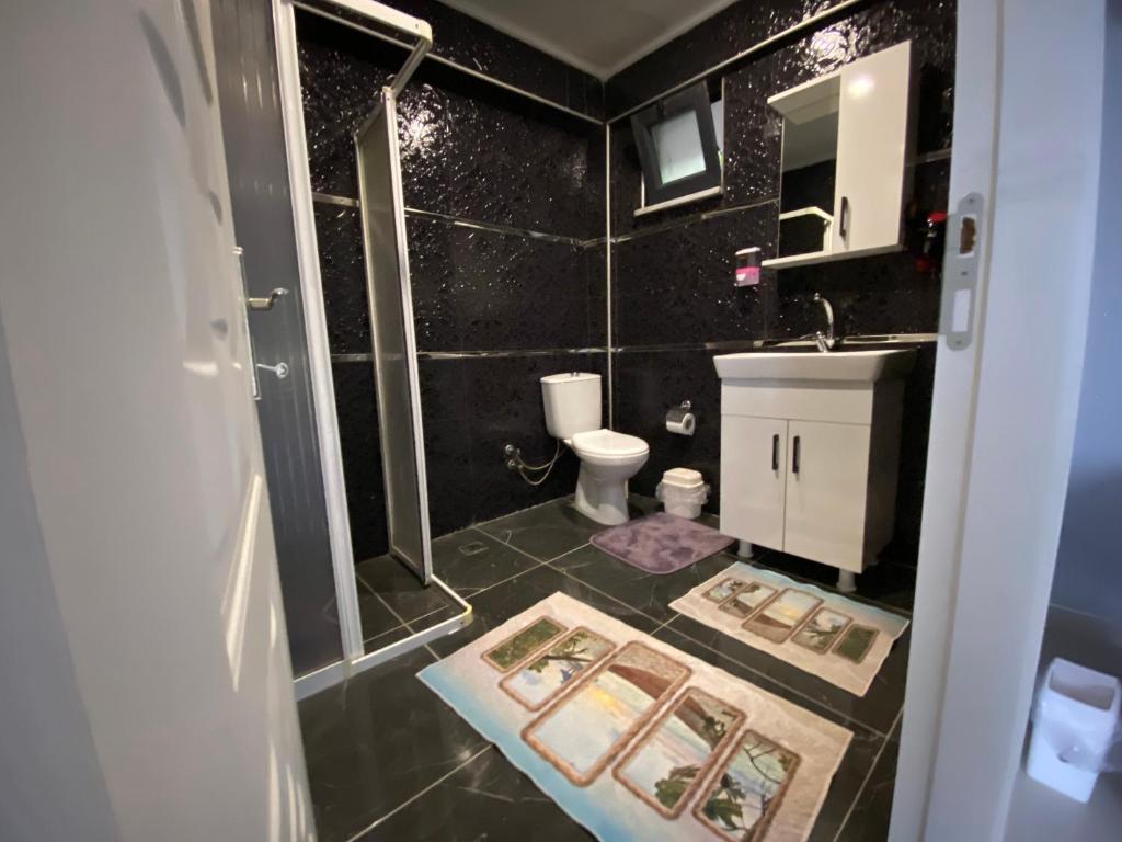 een badkamer met een douche, een toilet en een wastafel bij yuvacik kazli bahçe bungalov & taş otel in Yuvacık