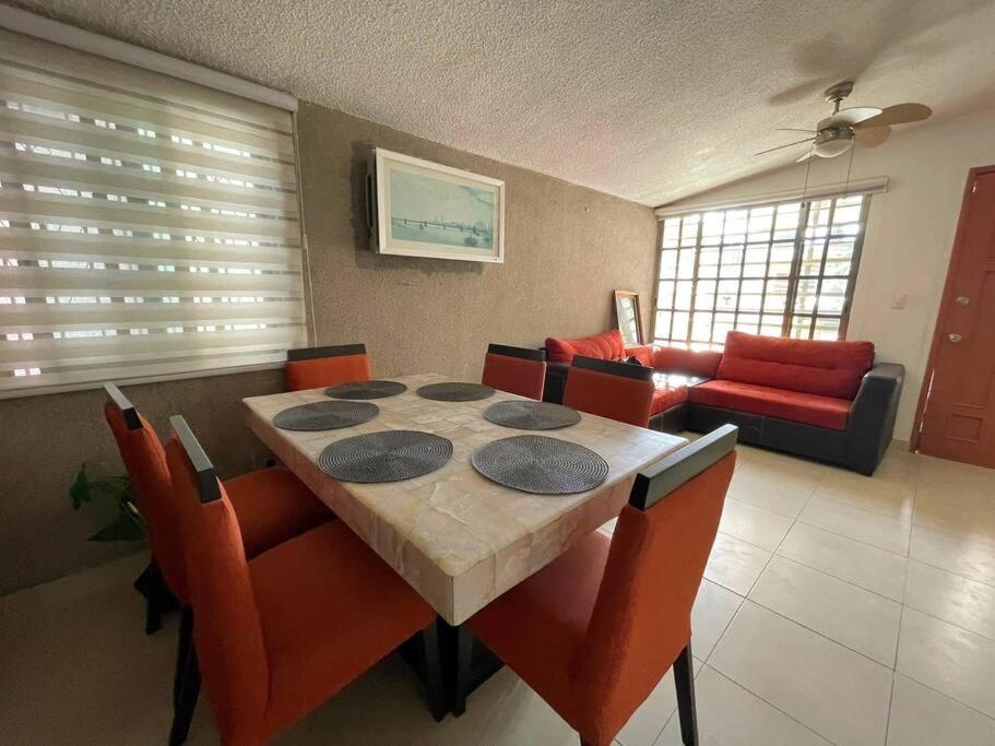 - une salle à manger avec une table, des chaises et un canapé dans l'établissement Espaciosa,Centrica y bonita casa, 10 personas, à Cancún