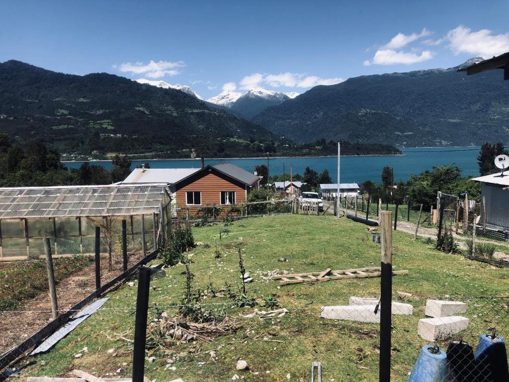 un jardín con vistas al lago y a las montañas en Cabaña rio cululi, sector Pocoihuen alto, en Cochamó