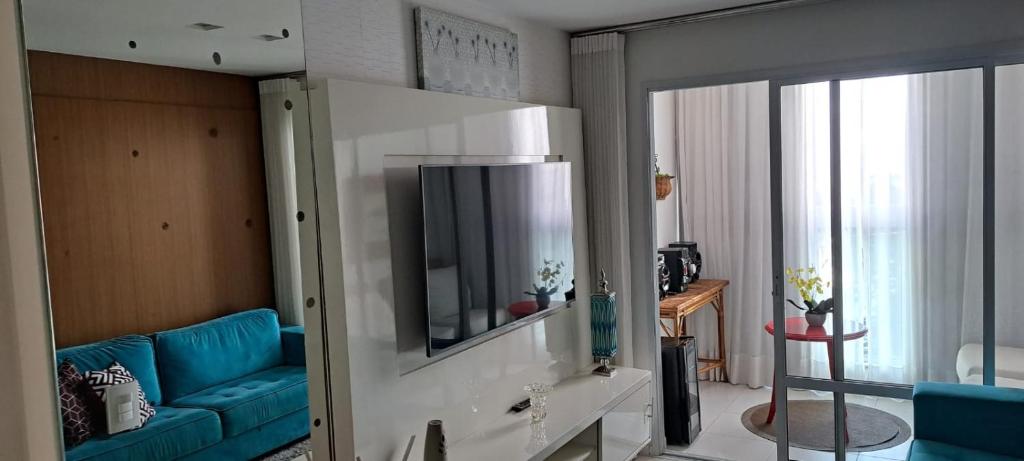 sala de estar con sofá azul y espejo en Maravilhoso 2 quartos na Praia de Itaparica - Vila Velha, en Vila Velha