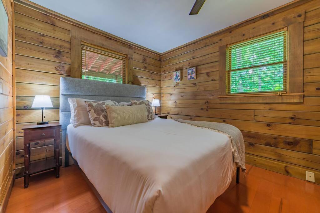 1 dormitorio con paredes de madera y 1 cama en una habitación en Couples Getaway Cabin near National Park w Hot Tub en Pigeon Forge