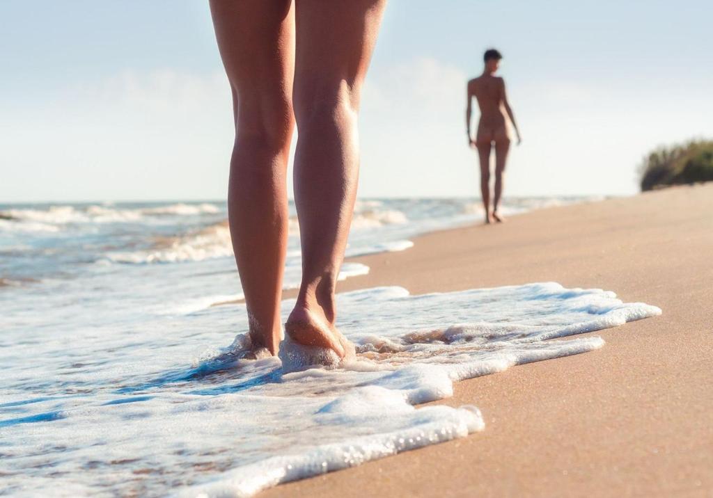 une femme debout sur la plage avec un homme dans l'océan dans l'établissement Studio Naturiste P.Nature 6, au Cap d'Agde