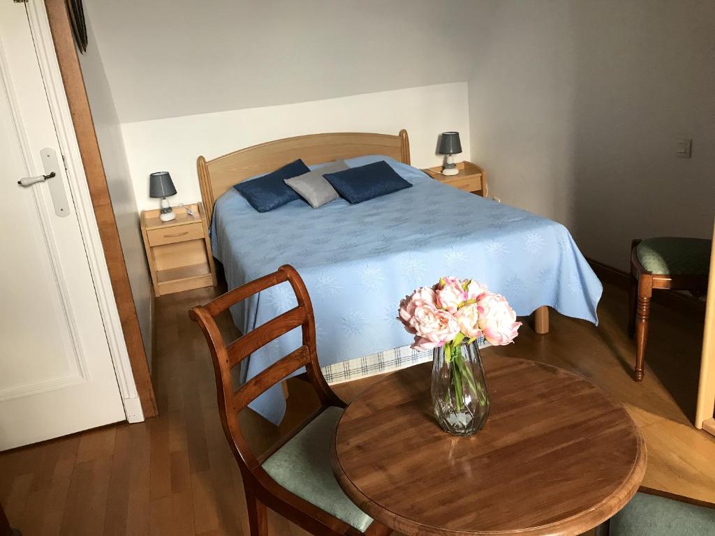 ポールバイユにあるAppartement lumineux avec vue sur la mer à Port-Bail 70 m² 4 pers.のベッドルーム1室(花瓶のあるテーブル付)