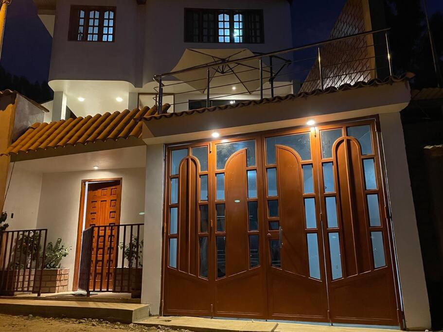 a house with a pair of surfboards on the doors at Casa Hospedaje “YURAQ WASI” in Huaraz