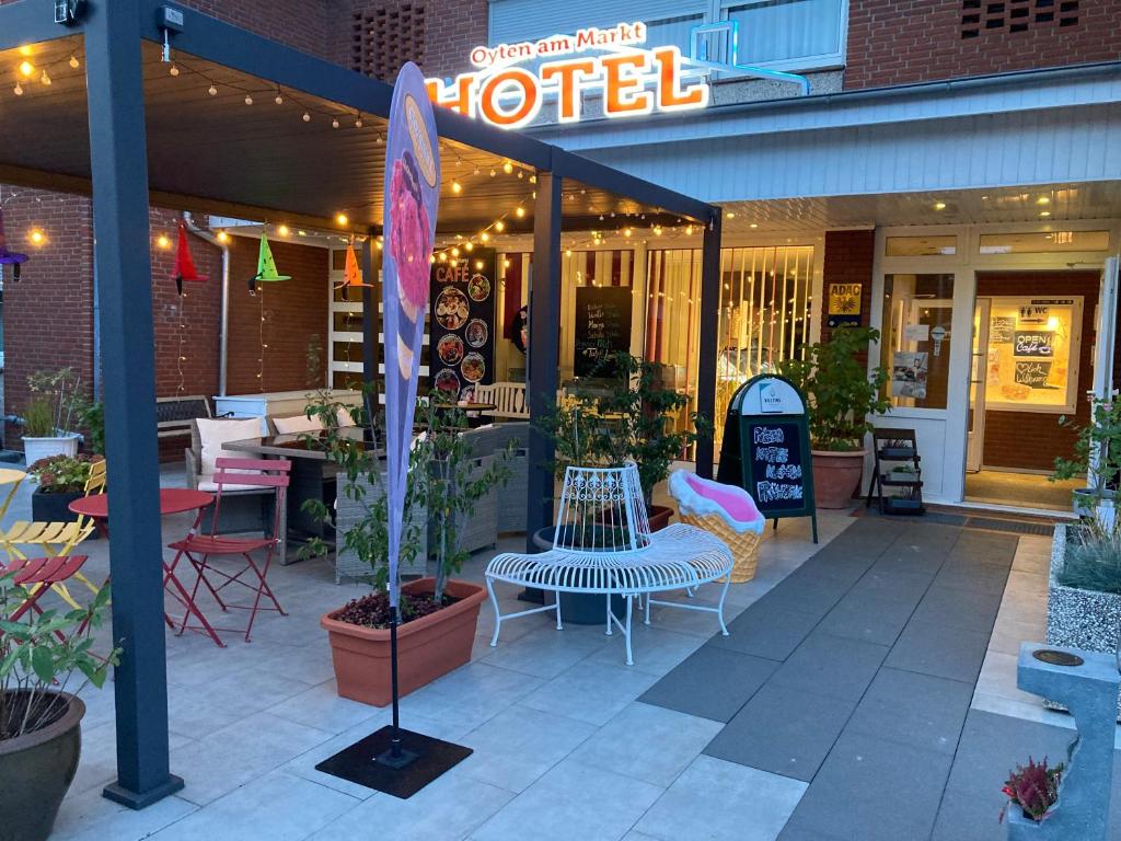 a hotel with a table and chairs and a sign at Hotel Oyten am Markt in Oyten